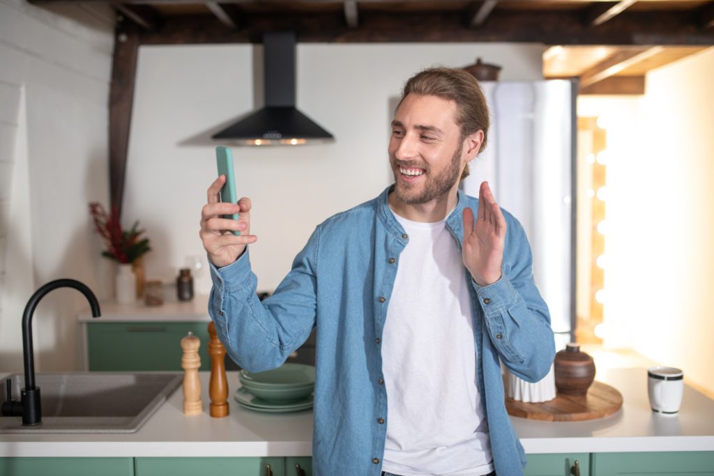 smiling-man-recording-a-video-message-at-home